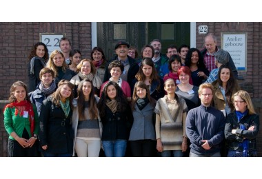 Groepsfoto van de internationale cursus voor steenconservering voor de ingang van het Ateliergebouw in Amsterdam. Foto: Lisya Bicaci