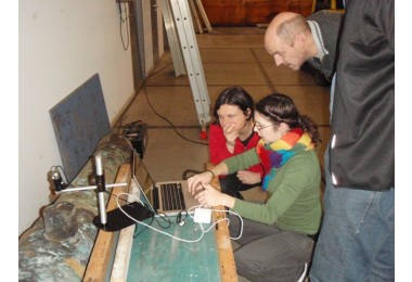 Ineke Joosten, Janneke Nienhuis en Frank Dallmeijer bekijken een bronzen kanon met een draagbare microscoop.