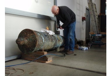 Lucas van Dijk takes a  sample of a bronze canon.